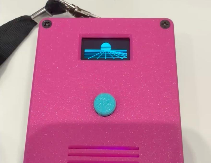 A finished badge on a lanyard, the retrowave sun and grid running on its screen