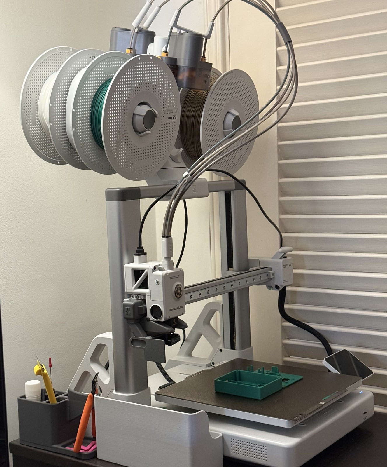 The A1 running a case test print, a green tray on the bed