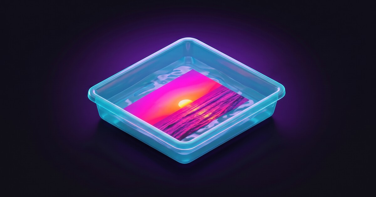 A glowing developing tray holding a photo of a sunset over the ocean